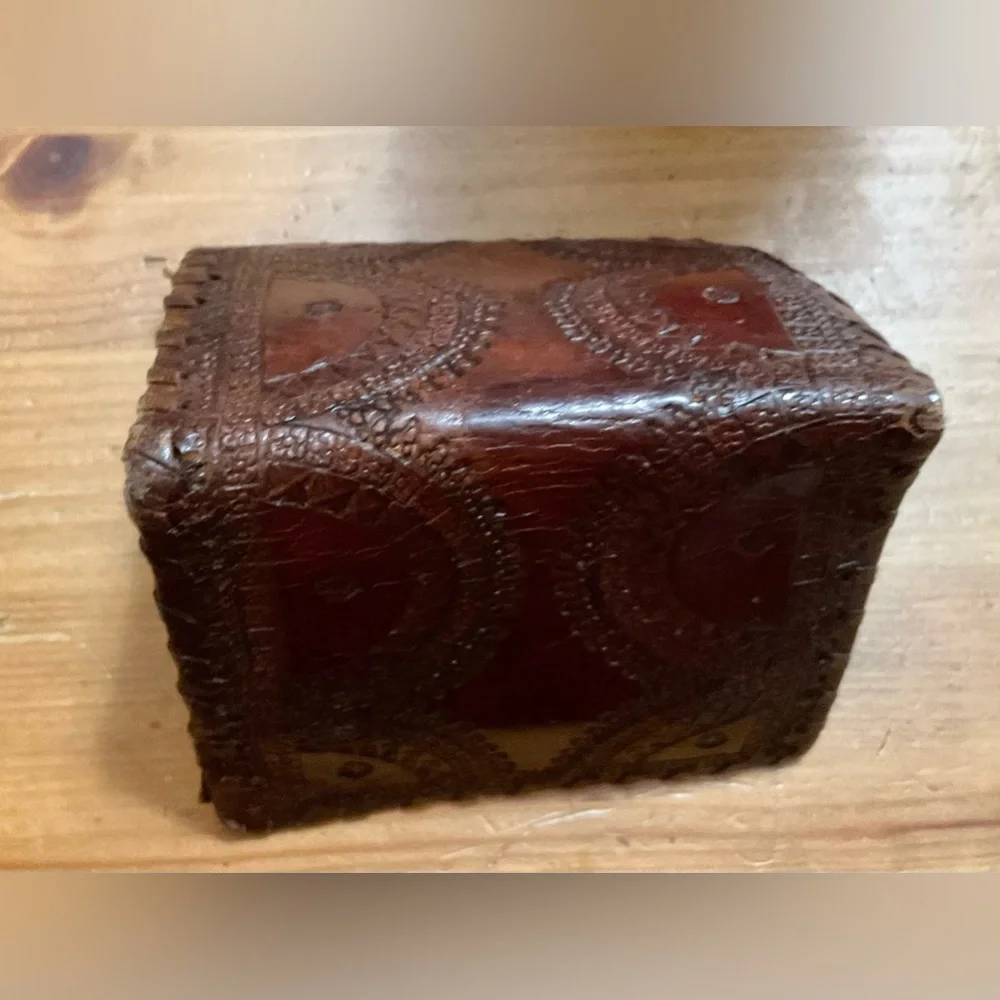Hand crafted tooled mens leather design bifold wallet laced stitching around it.
